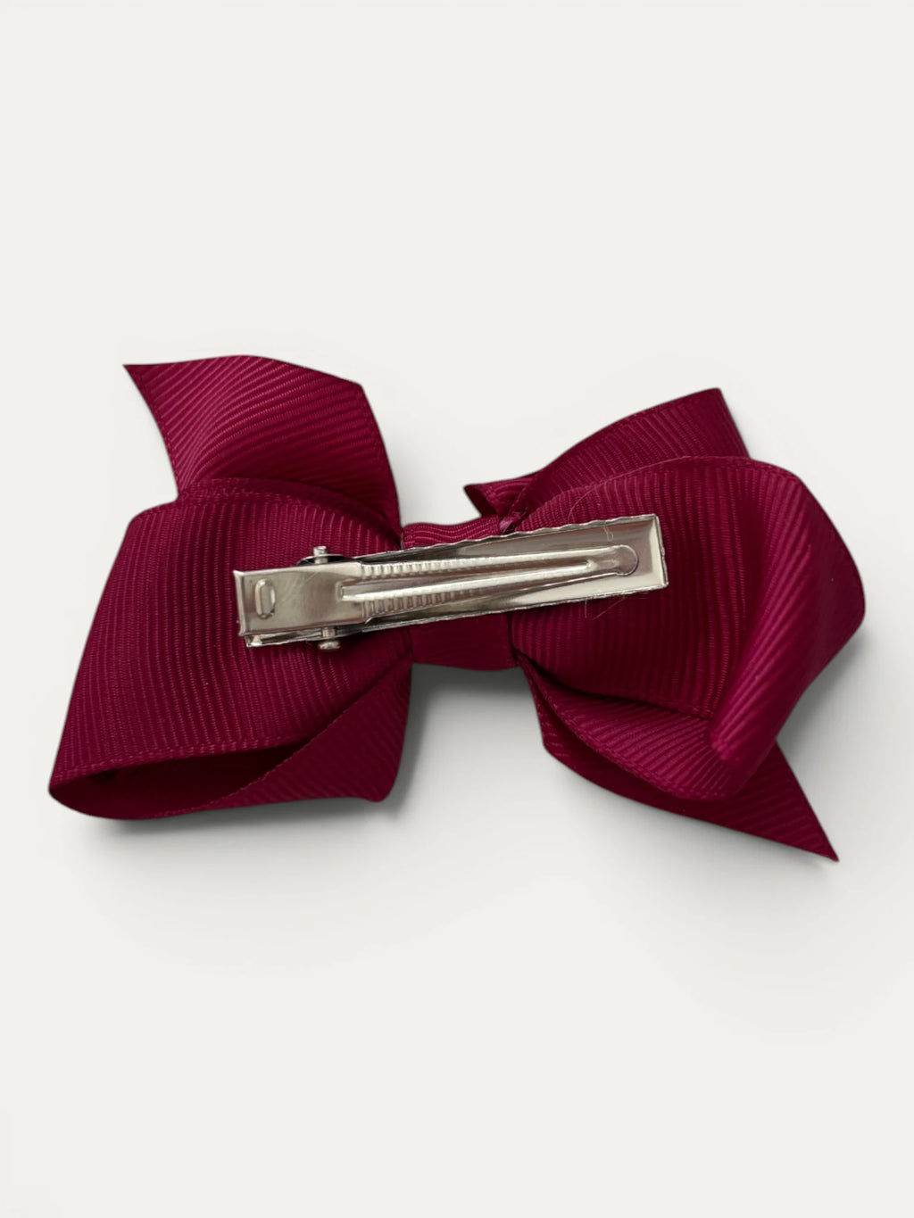Fine grosgrain bow hair clip for girls; elegant texture, feminine silhouette, made in Spain and shipped from Switzerland.