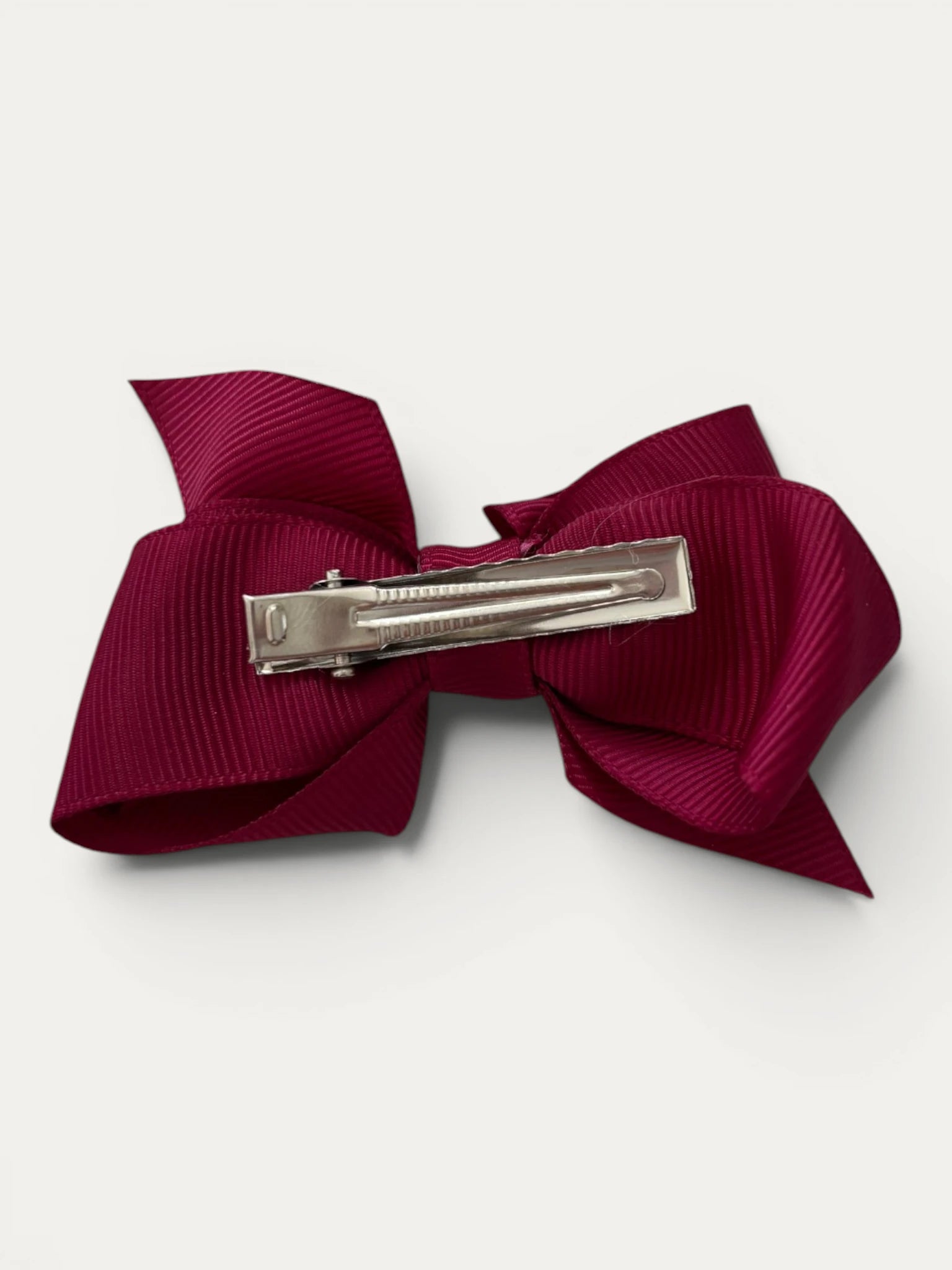 Fine grosgrain bow hair clip for girls; elegant texture, feminine silhouette, made in Spain and shipped from Switzerland.