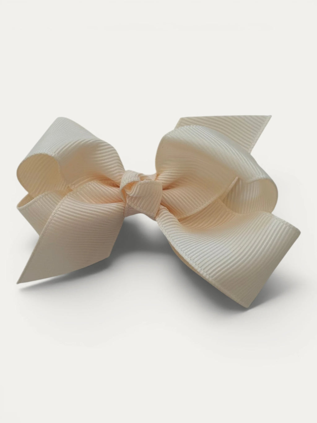 Fine grosgrain bow hair clip for girls; elegant texture, feminine silhouette, made in Spain and shipped from Switzerland.