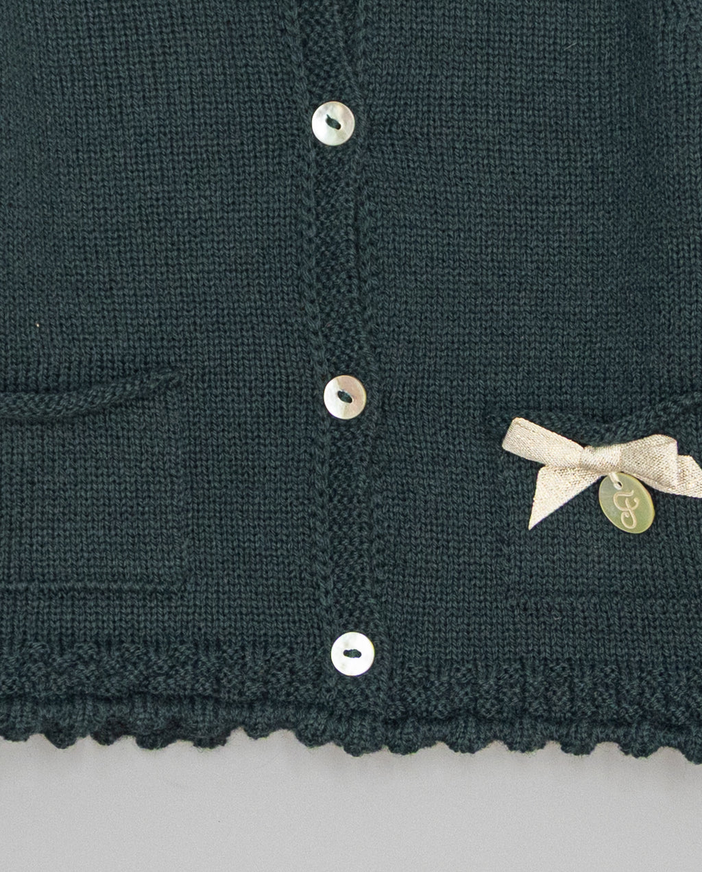 Dark green knitted kids cardigan with metallic bow and pearl initial button
