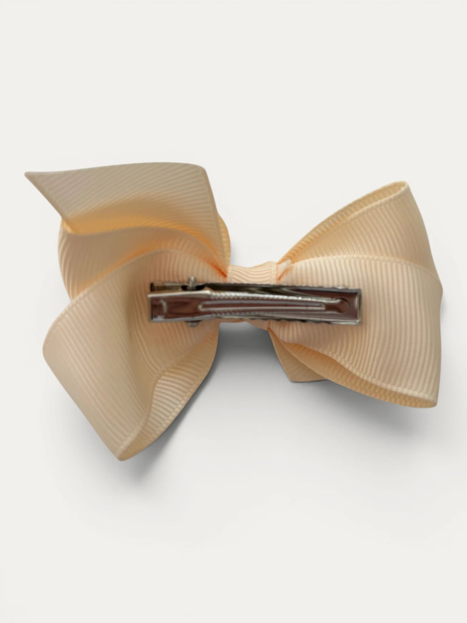 Fine grosgrain bow hair clip for girls; elegant texture, feminine silhouette, made in Spain and shipped from Switzerland.
