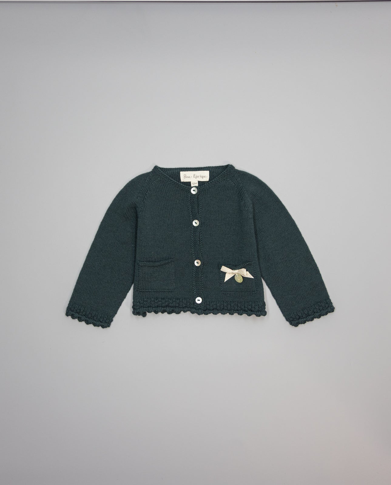 Dark green knitted kids cardigan with metallic bow and pearl initial button