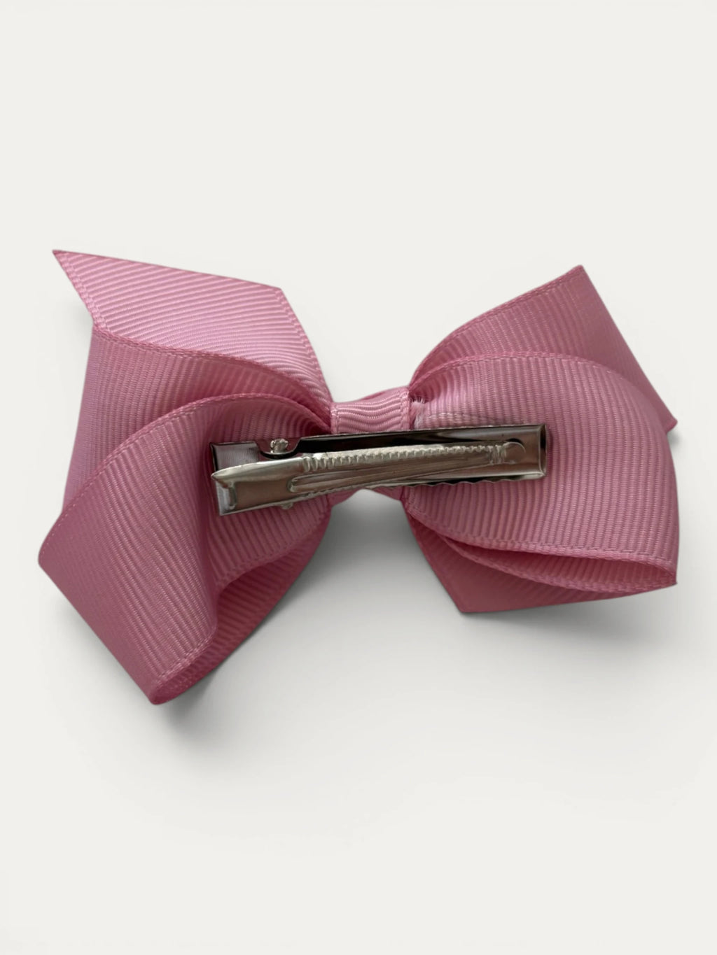 Fine grosgrain bow hair clip for girls; elegant texture, feminine silhouette, made in Spain and shipped from Switzerland.
