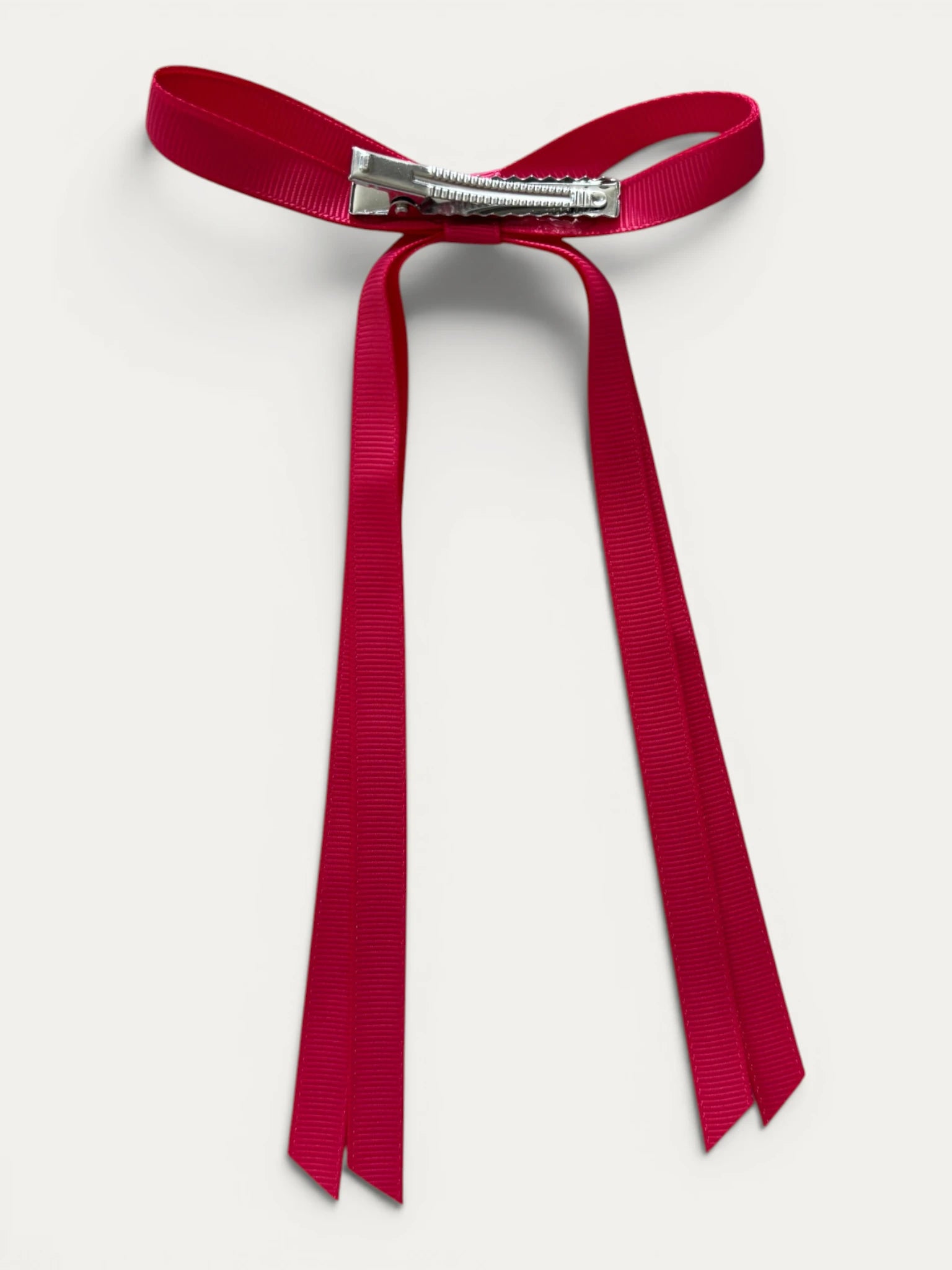 Classic long grosgrain bow clip for girls in Fuchsia; vibrant tone, elegant silhouette, made in Spain and shipped from Switzerland.