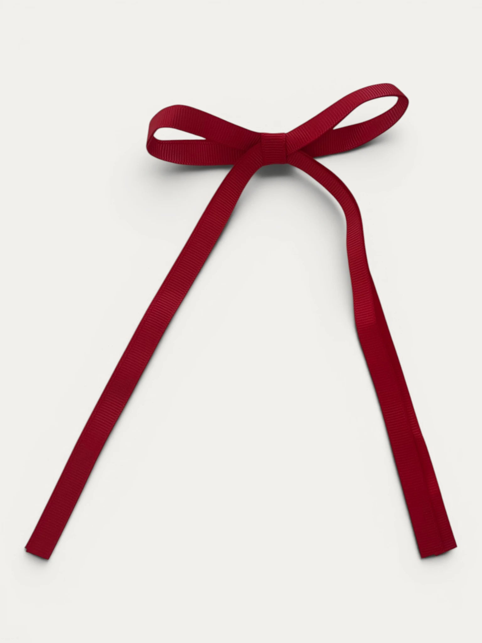 Classic long grosgrain bow clip for girls in Red; bright tone, elegant silhouette, made in Spain and shipped from Switzerland.