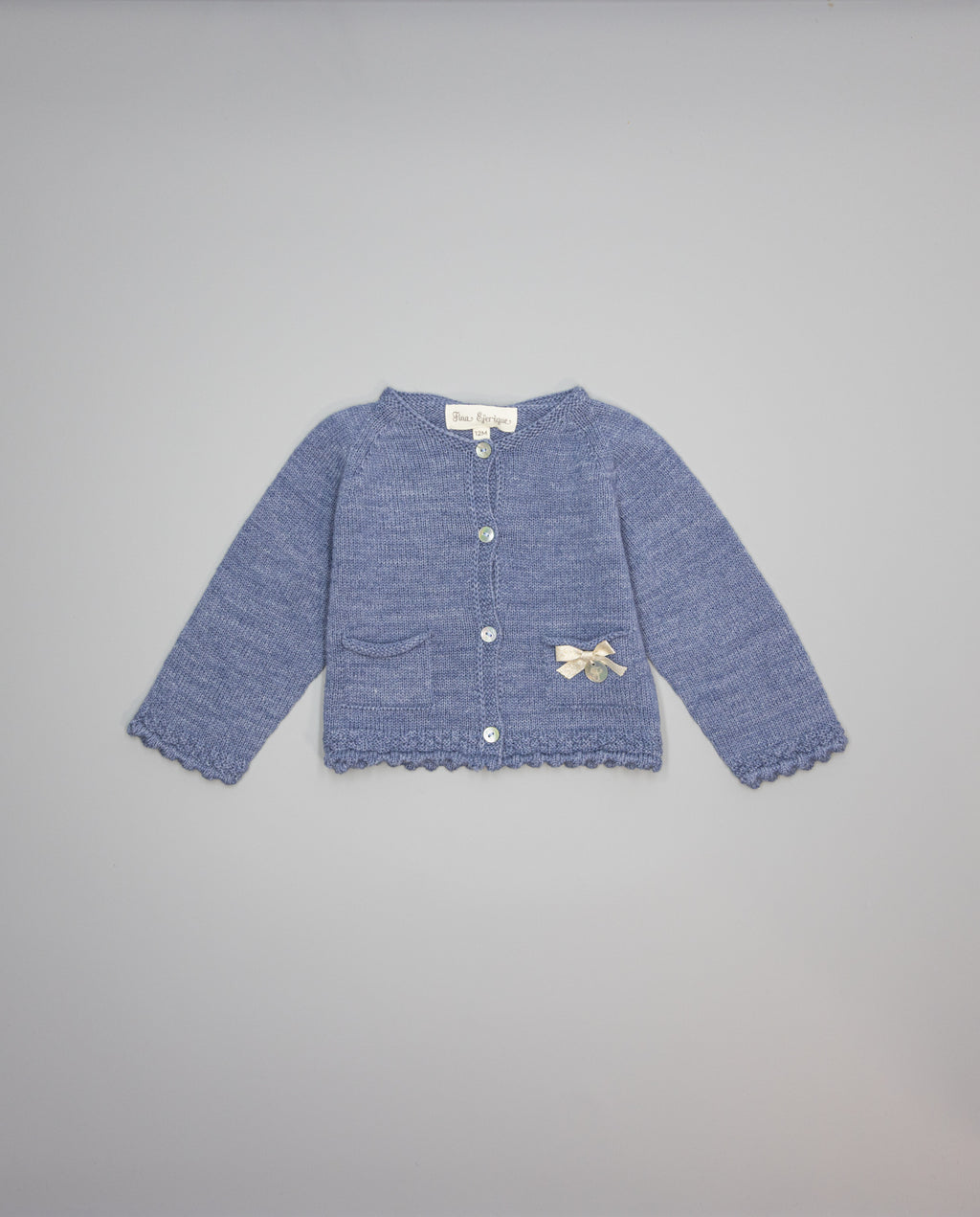 Blue knitted kids cardigan with metallic bow and pearl initial button