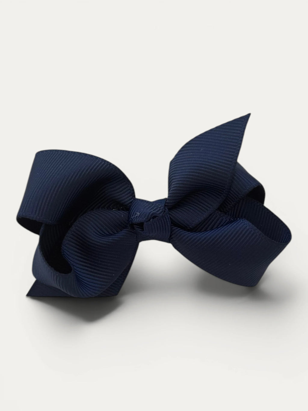 Fine grosgrain bow hair clip for girls; elegant texture, feminine silhouette, made in Spain and shipped from Switzerland.