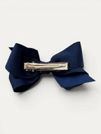 Fine grosgrain bow hair clip for girls; elegant texture, feminine silhouette, made in Spain and shipped from Switzerland.